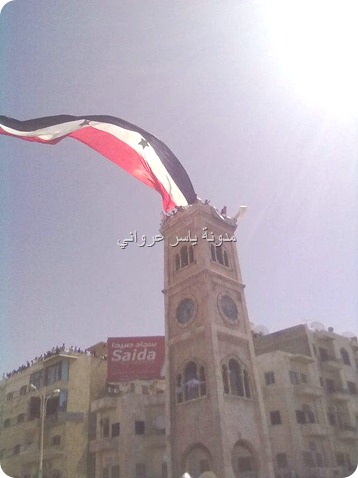 علم سوريا على ساعة حماة